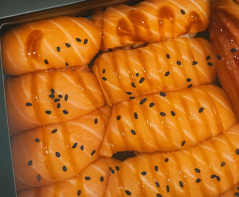 Sushis au saumon laqués et parsemés de sésame noir